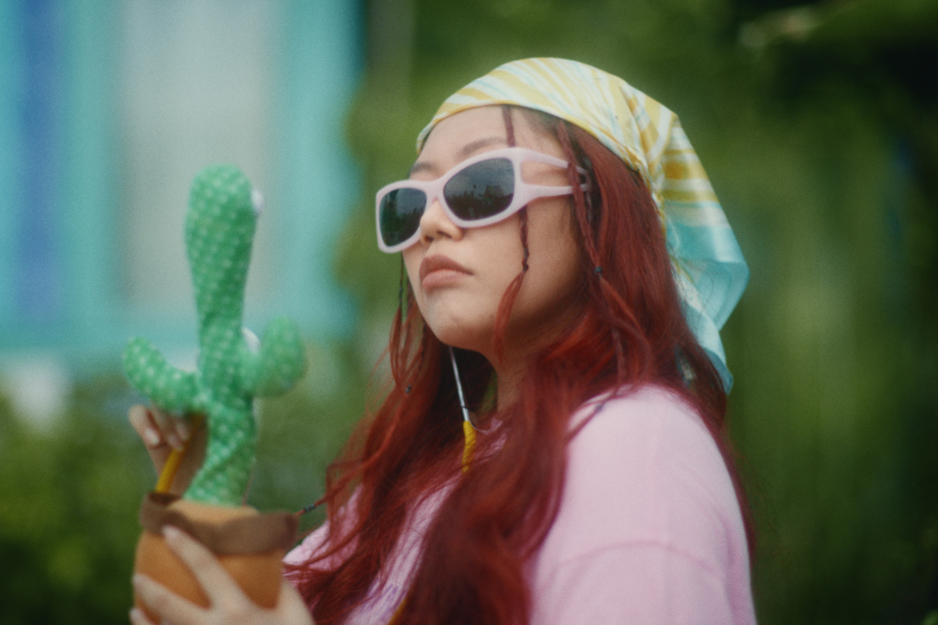 A woman in sunglasses holding a cactus