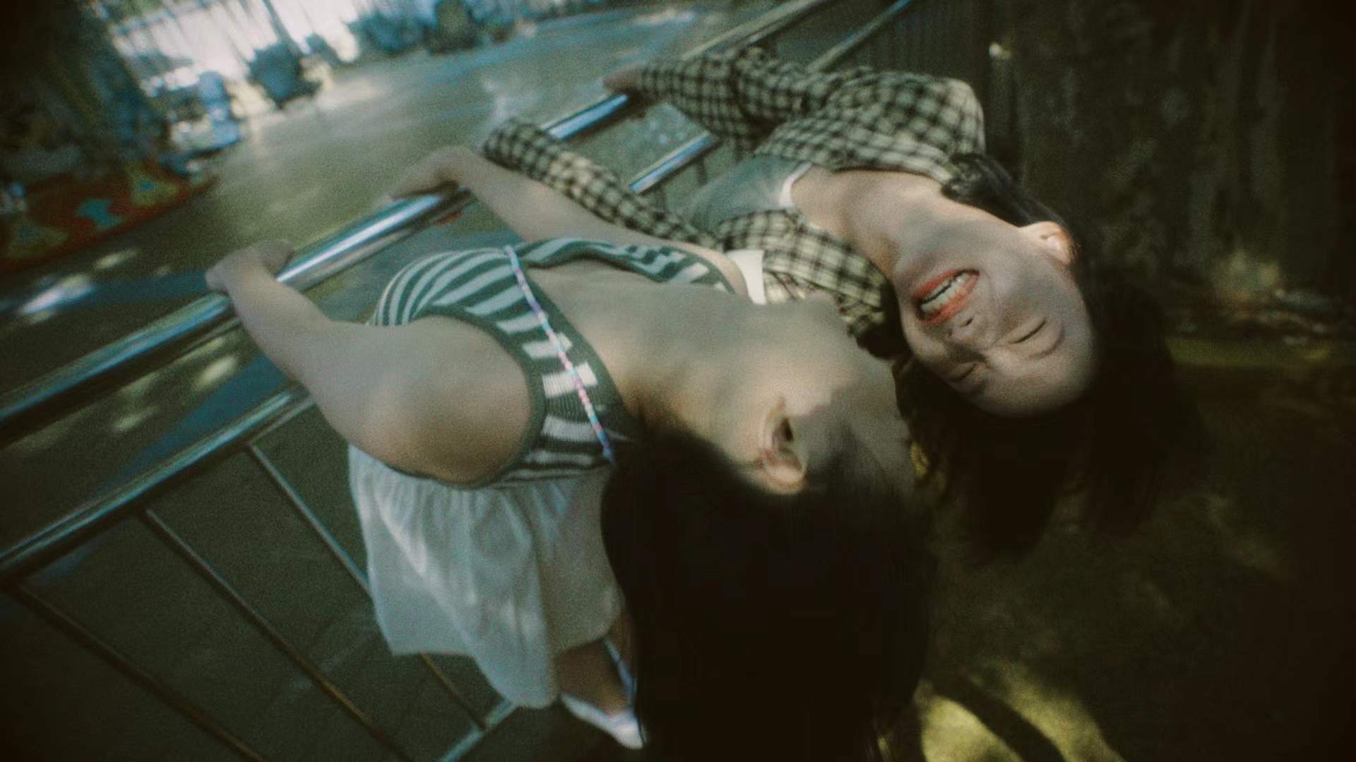 Two women leaning back over a railing