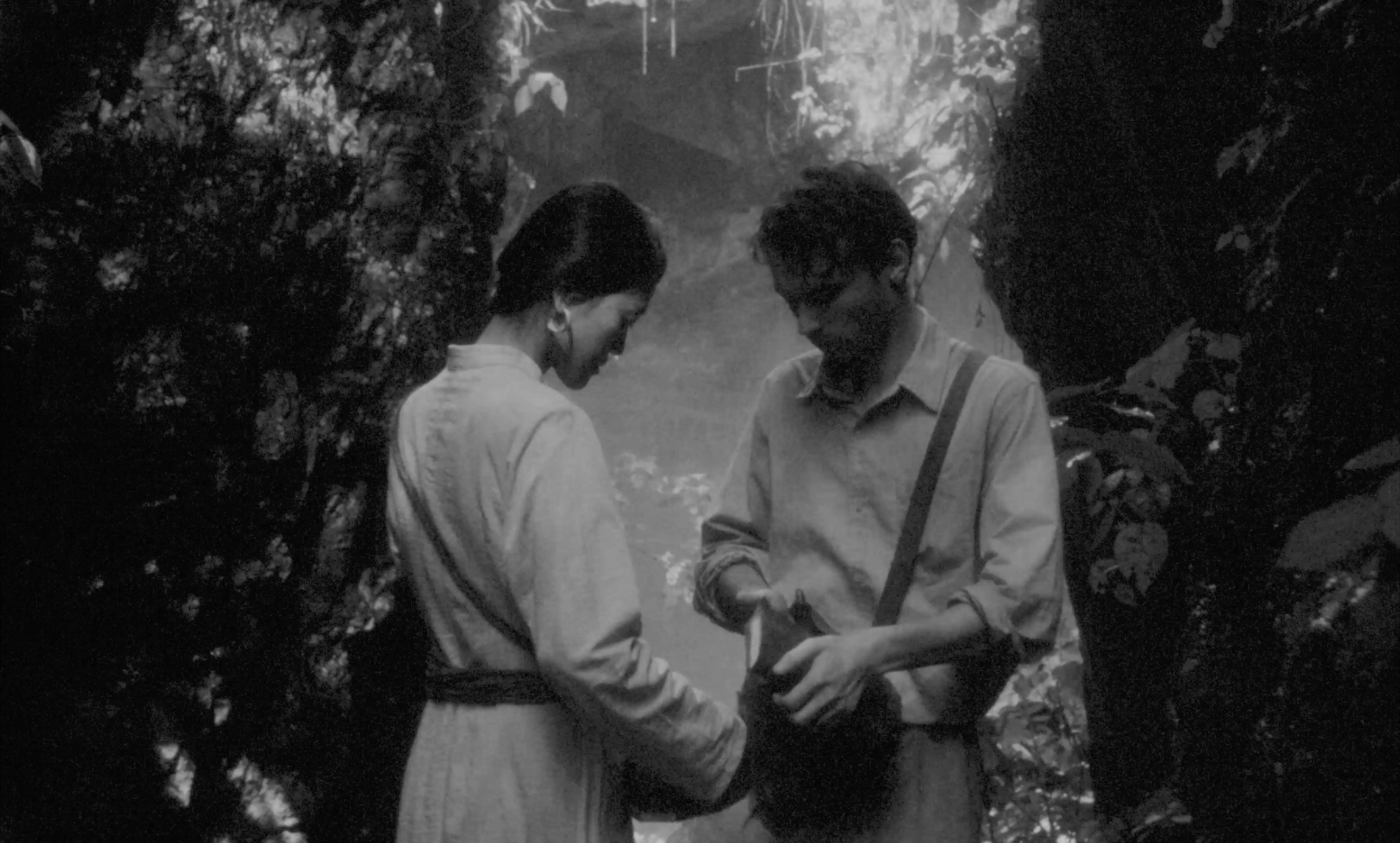 Two figures in a forest clearing