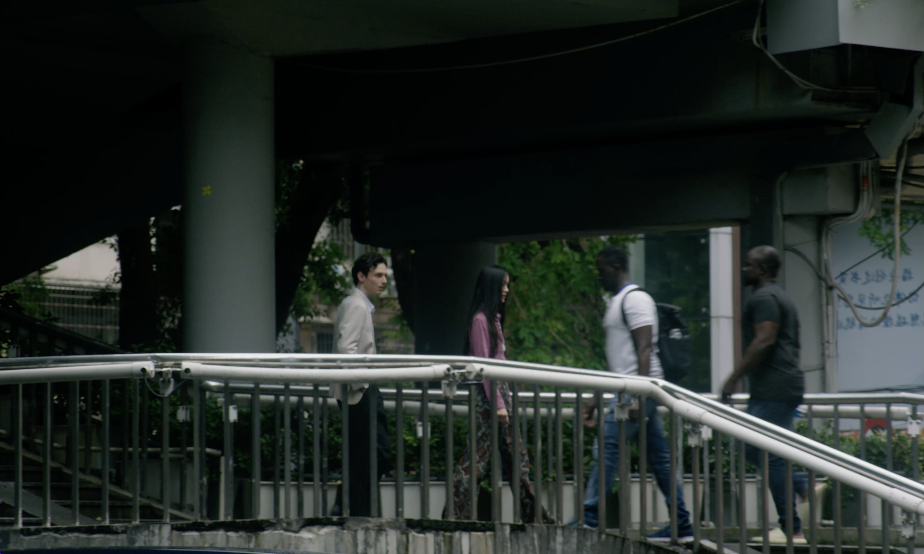 Figures passing on an urban walkway