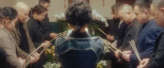 A gathering around a coffin holding incense