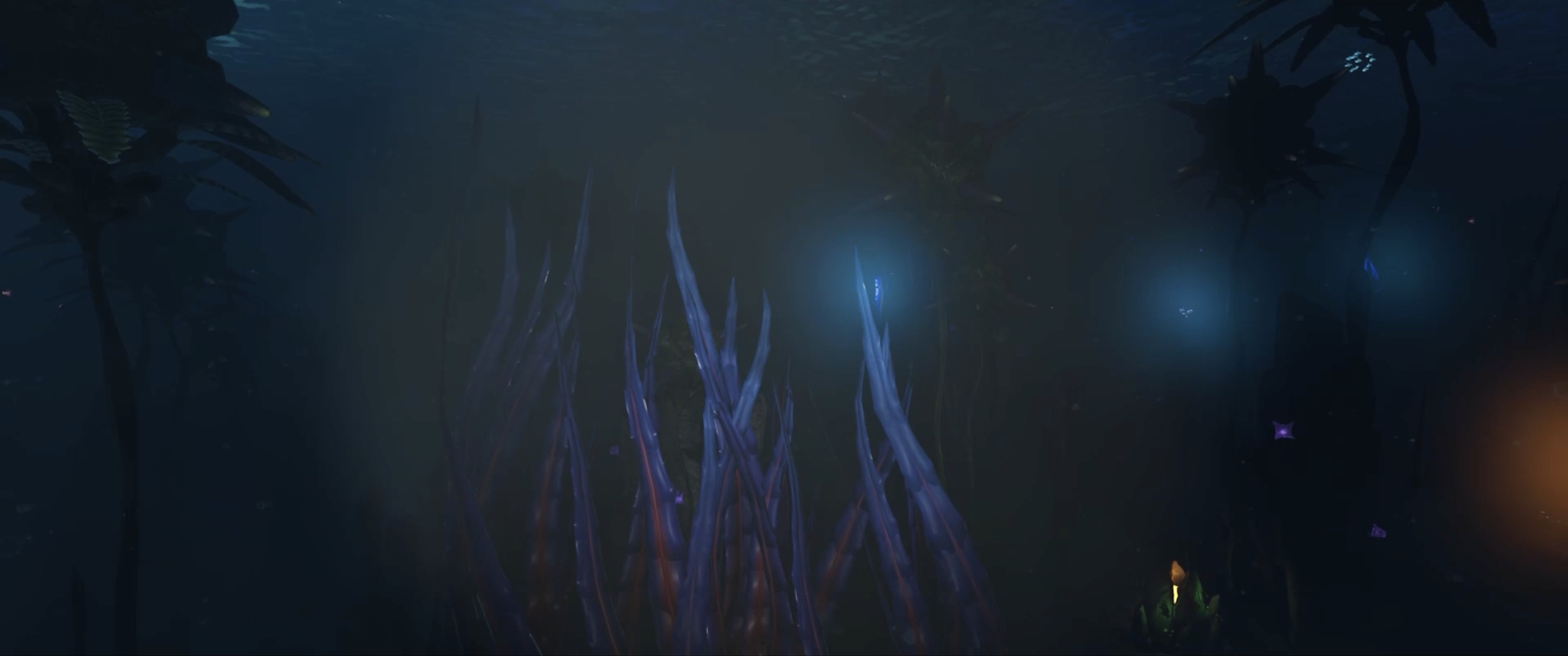 A dark underwater landscape with luminous plants