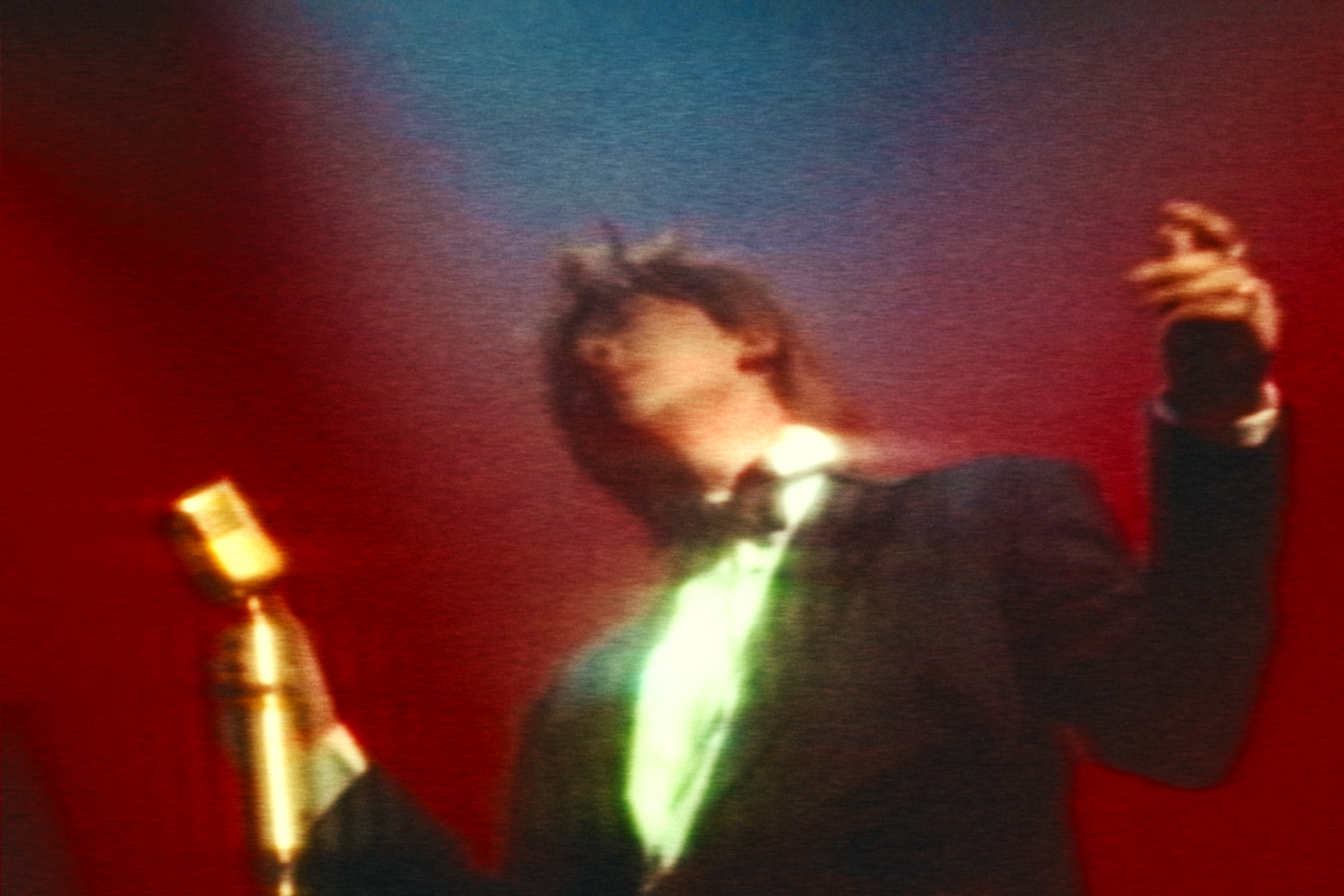 Sean Tang performing beneath red and blue light