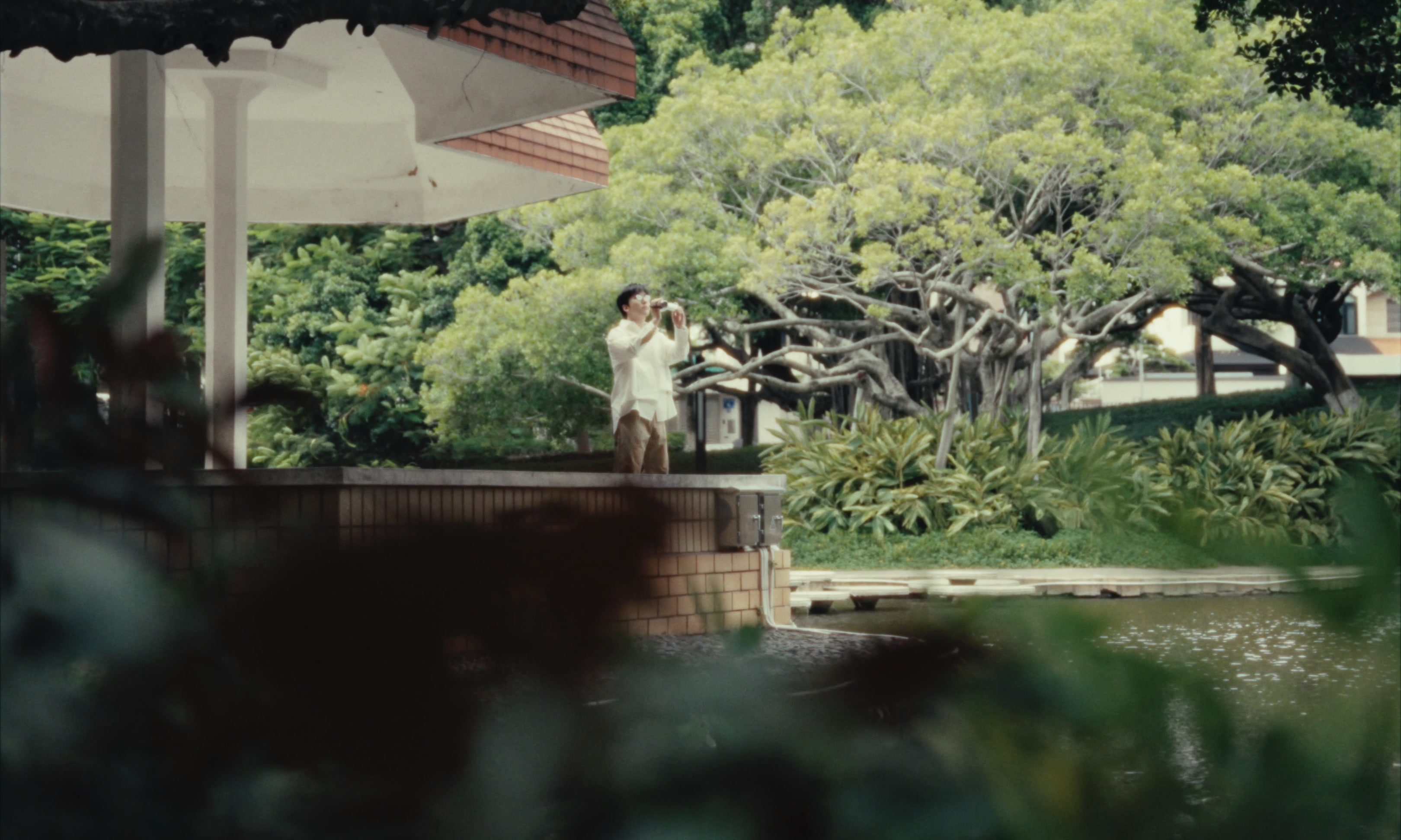 Sean Tang beside a pavilion and spreading trees