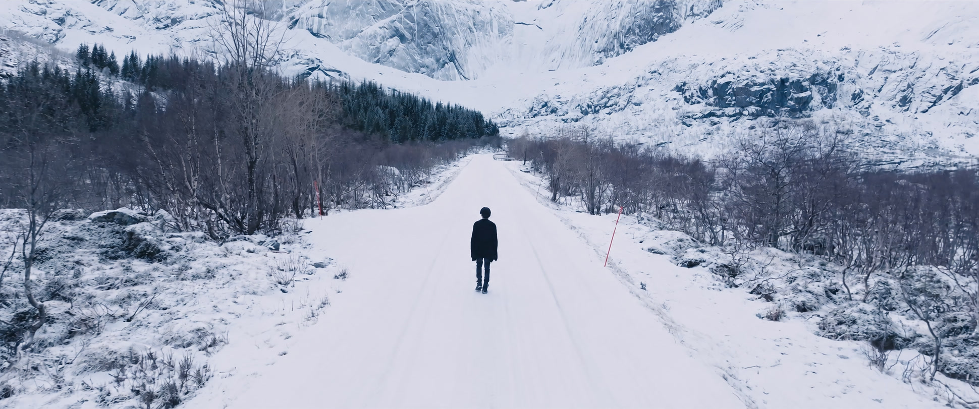 A lone figure on a snowy mountain road