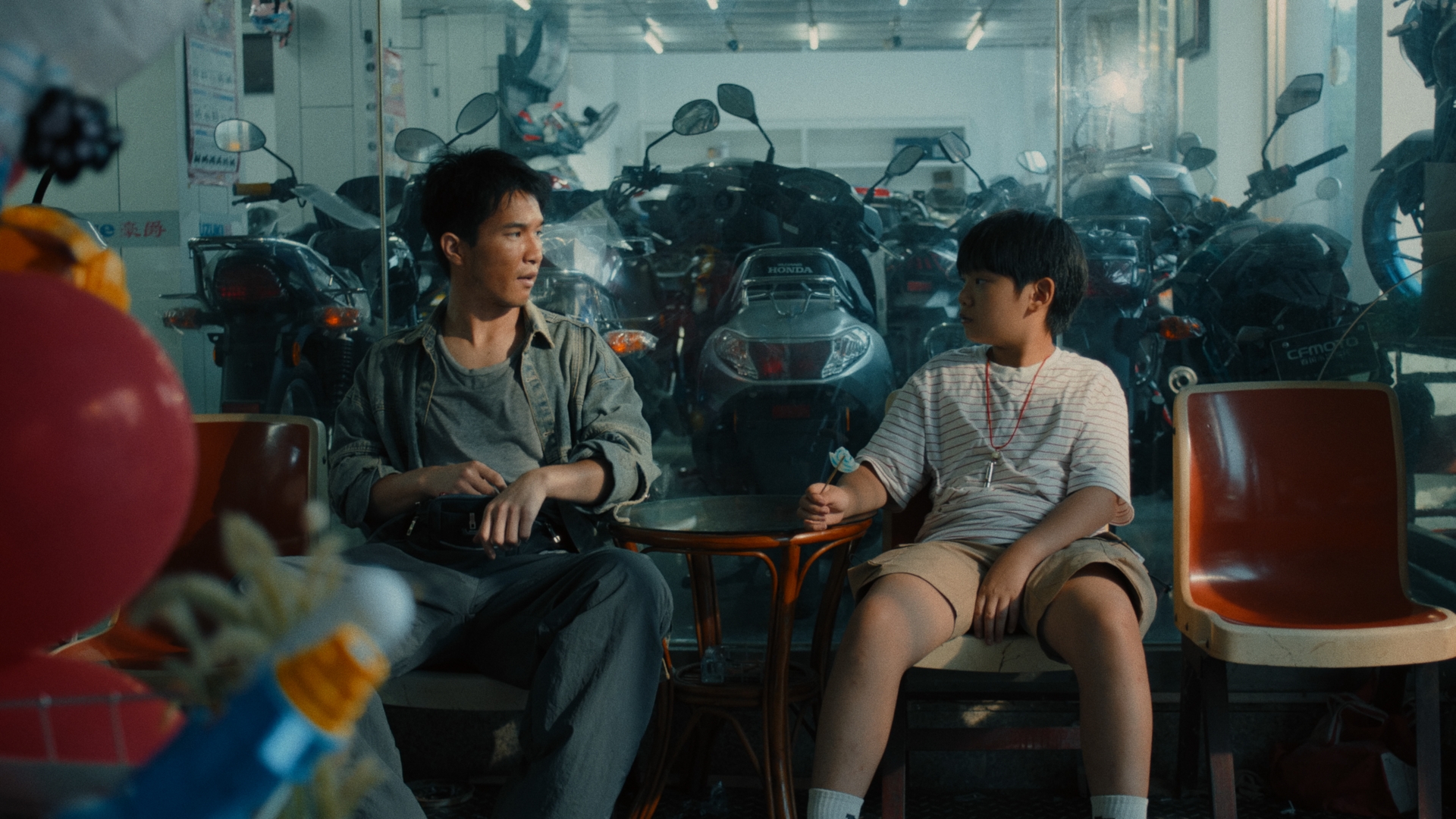 A man and boy in a motorcycle shop