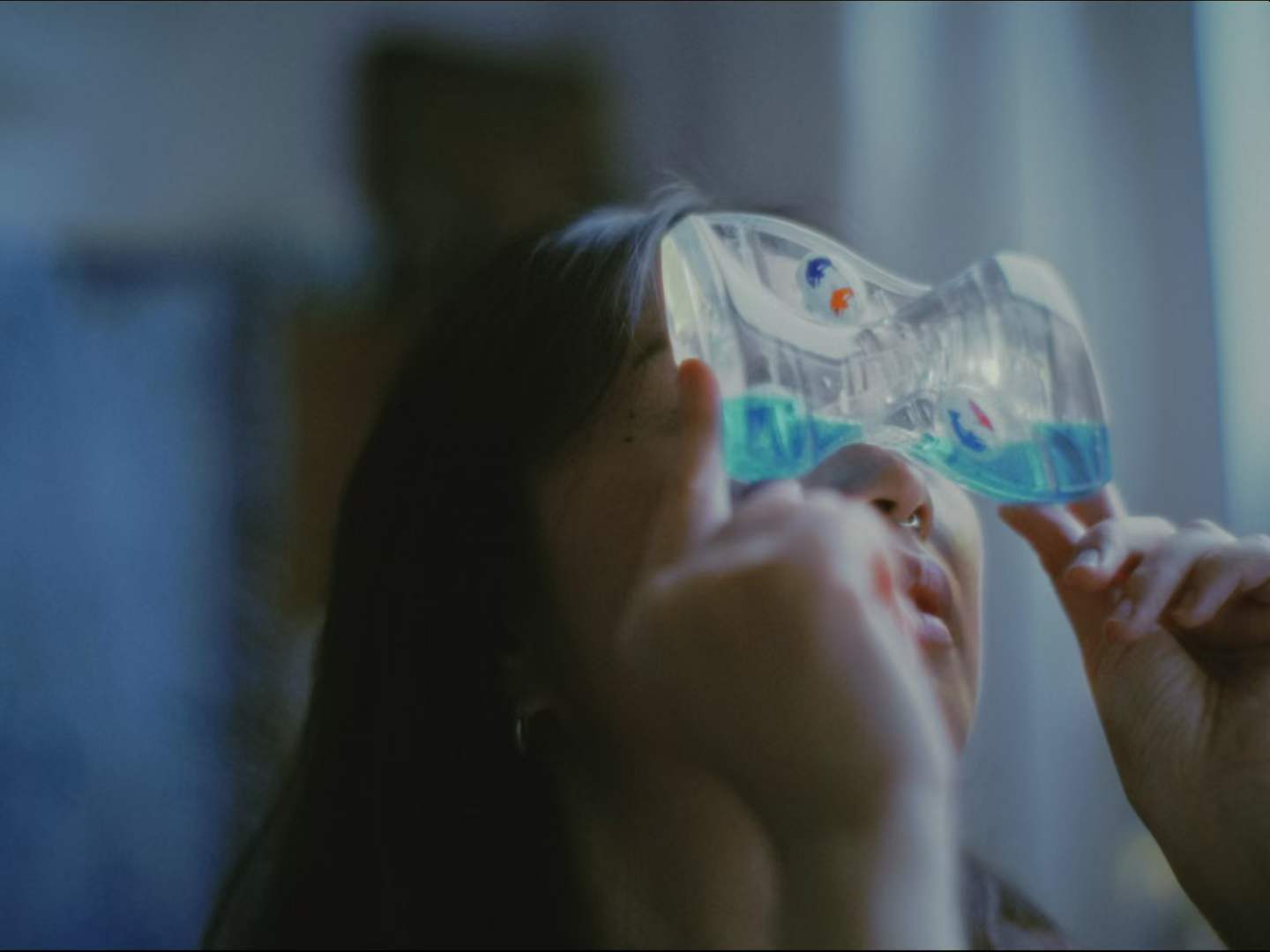 A woman holding a water-filled toy to her face