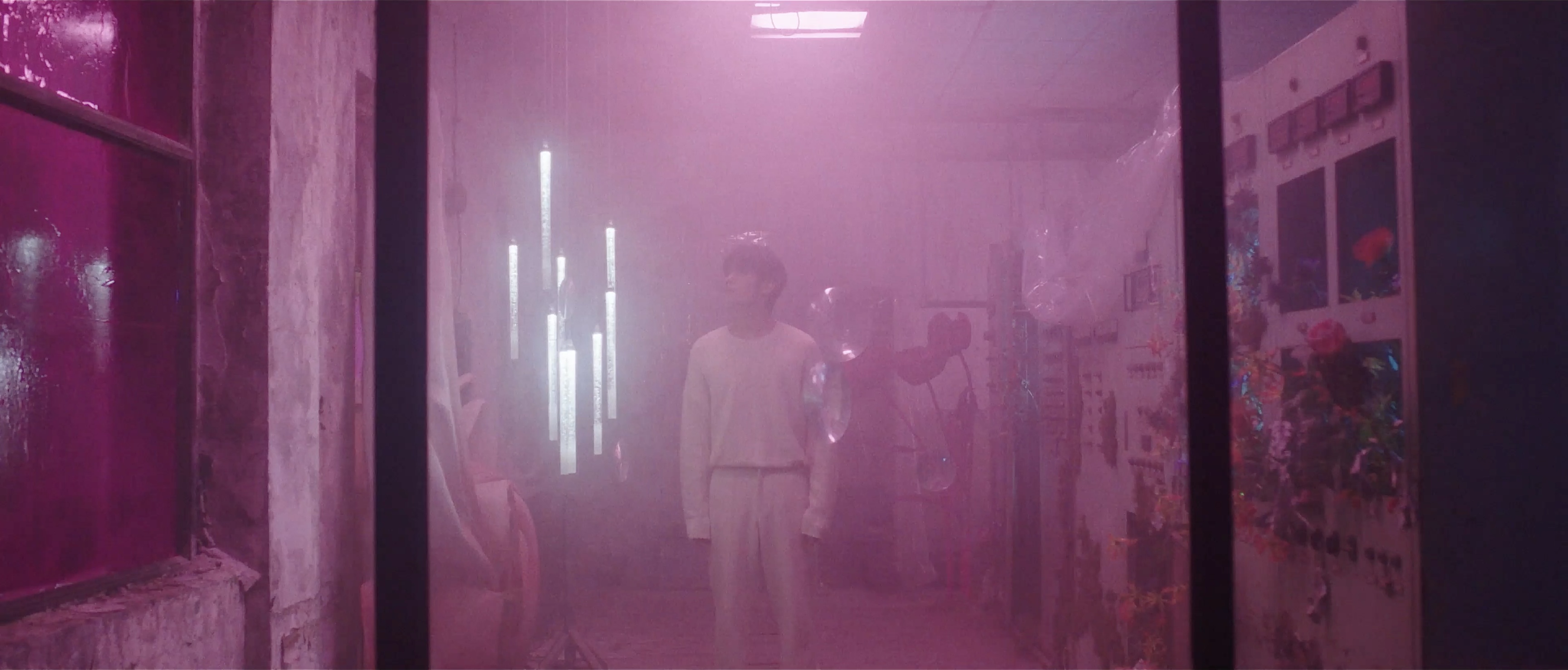 A figure in a pink-lit room