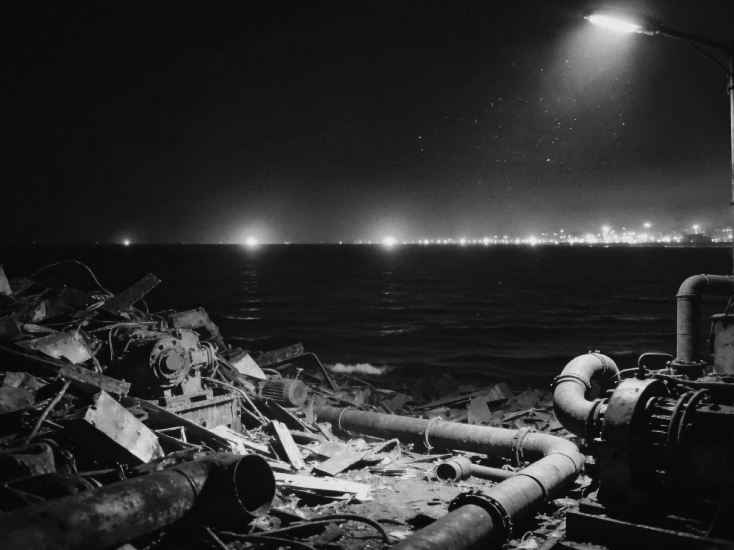 A scrapyard overlooking the sea at night
